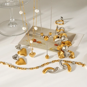 Elegant gold and silver tone jewelry set with heart earrings and pearl necklace