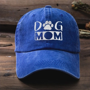 Close-up of white DOG MOM embroidery and paw print on washed blue cotton baseball cap