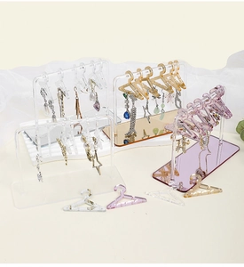 Detailed view of clear and gold acrylic hanger earring stands for jewelry display