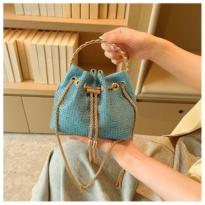 Detailed view of blue rhinestone bucket bag with golden round handle and chain strap