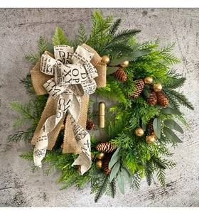 Macro detail of Christmas wreath with pine cones, golden bells and burlap bow decoration