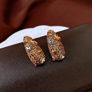 Boucles d'oreilles vintage goutte d'eau avec strass ambrés sur fond de soie marron chaud