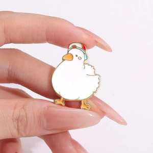 Cute white cartoon duck enamel brooch with red and blue baseball cap in hand display