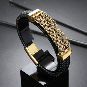 Detail of black braided leather men's bracelet with gold chain and magnetic clasp