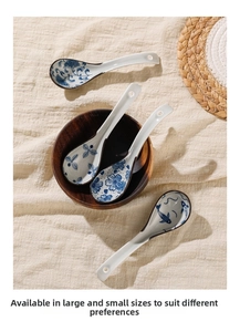 Japanese ceramic soup spoons with blue floral pattern on rustic wooden bowl