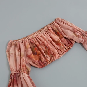 Close-up of pink floral chiffon off-shoulder crop top with elastic neckline details