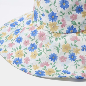Gros plan du motif floral et de la texture du tissu sur un chapeau de soleil à bord large