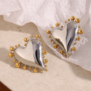 Close-up of heart earrings with silver polished finish and gold beaded edges