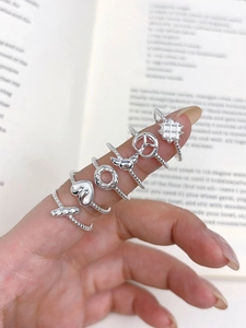 Macro view of S925 sterling silver rings with cute heart and donut charms on a book
