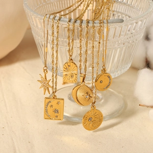 18K gold plated celestial star and moon necklaces hanging on a glass display