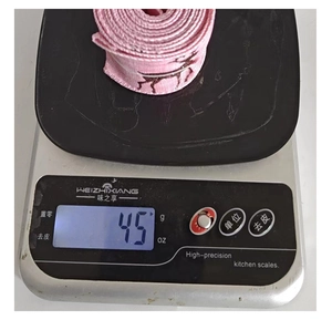 Báscula digital que muestra el peso de 45g de una cinta rosa de Navidad con diseño de reno