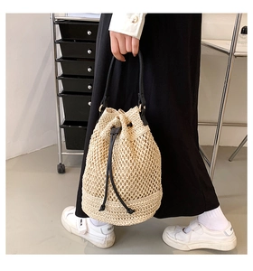 Detail showing beige paper rope bucket bag weave and contrasting black drawstring straps