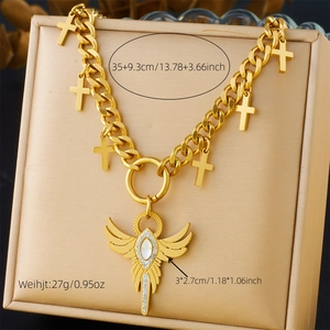 Detail of gold chain necklace with angel wing pendant and white zircon inlay details