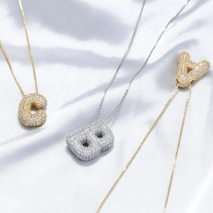 Detail of A, B, C balloon alphabet pendants with cubic zirconia in gold and silver finish
