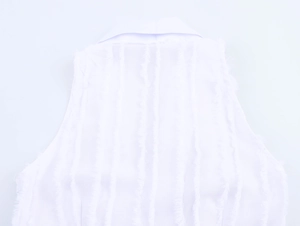 Close-up of white textured sleeveless dress with vertical pattern and tassel fringe detail