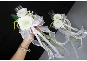 Detail of white artificial rose wedding glass decoration with elegant satin bow