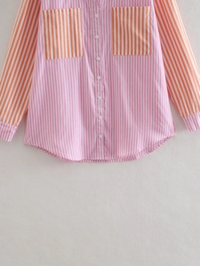 Close-up of pink and orange vertical stripe shirt with button placket and front pockets