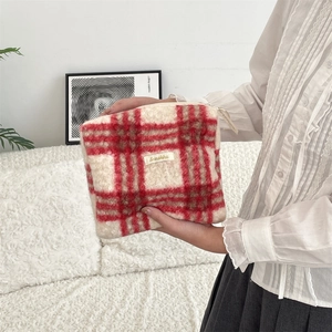 Detail van de rood-wit geruite pluche toilettas met zachte textuur en geweven merklabel