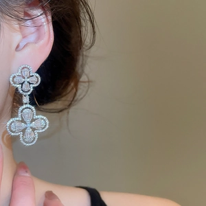 Detail shot of double-layer silver clover earrings with sparkling cubic zirconia inlay
