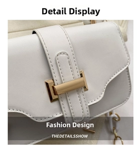 Detail of white leather handbag showing gold rectangular clasp and neat stitching