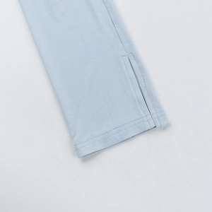 Detail view of the side slit and fine knitted texture on light blue off-shoulder top
