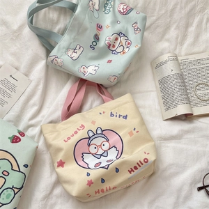 Detail of canvas tote bags featuring cute rabbit and bird prints with carry handles