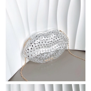 Close-up of lip-shaped acrylic clutch bag with clear crystals and golden chain strap