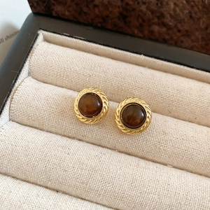 Detail of vintage round tiger eye stud earrings with gold twisted frame and resin inlay