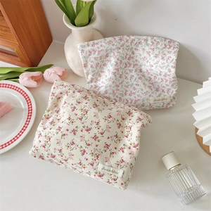 Detailed texture of cotton floral makeup bags in an elegant lifestyle desktop setting