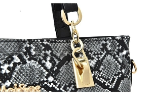 Detail of snake pattern embossed leather bag with gold chain and logo hardware