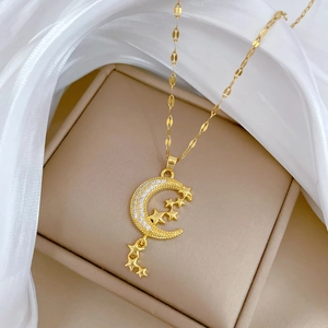 Detail of gold moon and star pendant with crystal inlay on soft silk fabric