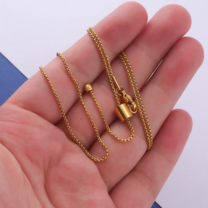 Macro shot of gold adjustable box chain with sliding stopper and polished finish