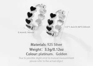 Detail view of 925 sterling silver heart hoop earrings with black enamel inlay