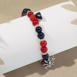 Detail of red and black beaded stretch bracelets with silver spider pendant on a display