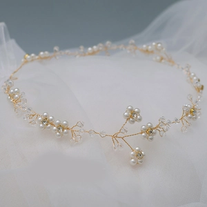 Detail of bridal gold hair vine with white pearls and crystals on soft tulle