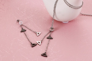 Detail of silver long tassel earrings and double-layer triangle necklace set