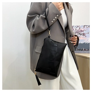 Fashionable black faux leather clutch bag with geometric stitching and tassel detail