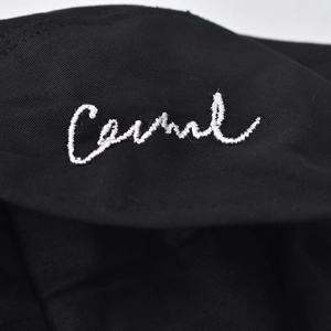 Detail of white 'Casual' embroidery on premium black knit beret with fine stitching texture