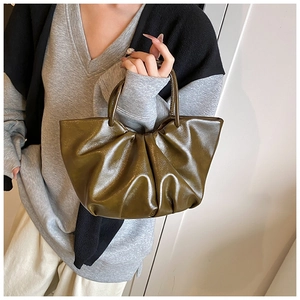 Detailed view of an olive green pleated dumpling bag with soft leather texture