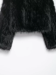 Close-up detail of plush black faux fur jacket showing high-quality fiber texture and hem