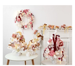 Close-up of white mini Christmas trees with gingerbread men and red candy ornaments
