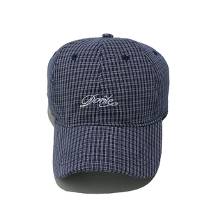 Detail of embroidered Done letter logo on navy blue plaid check pattern cotton baseball cap