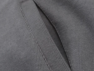 Close-up of ribbed dark grey knit fabric texture and seam detailing on hooded sweatshirt