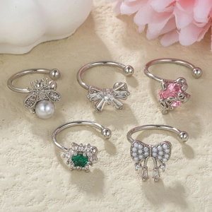 5-piece silver ear cuff set with pearls, crystals, and delicate charms on beige texture