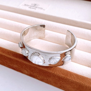 Detailed close-up of a silver cuff bracelet featuring five teardrop moonstone gemstones
