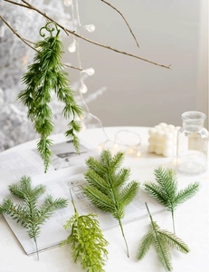 Close-up of artificial pine needles and PE green leaves for Christmas DIY decor on books