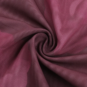 Vue macro du tissu en maille bordeaux respirant montrant la texture fine et la douceur