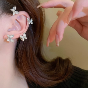 Detailed side view of silver butterfly ear cuff with sparkling white zircons on model