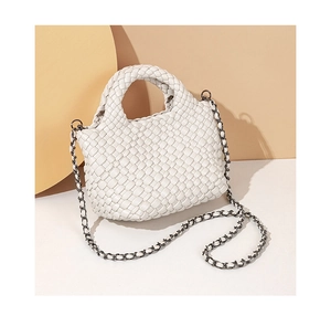 Detailed macro view of white woven leather texture and elegant metal chain strap detail