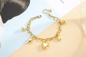 Vue détaillée du bracelet double couche en acier inoxydable doré avec pendentifs cœurs